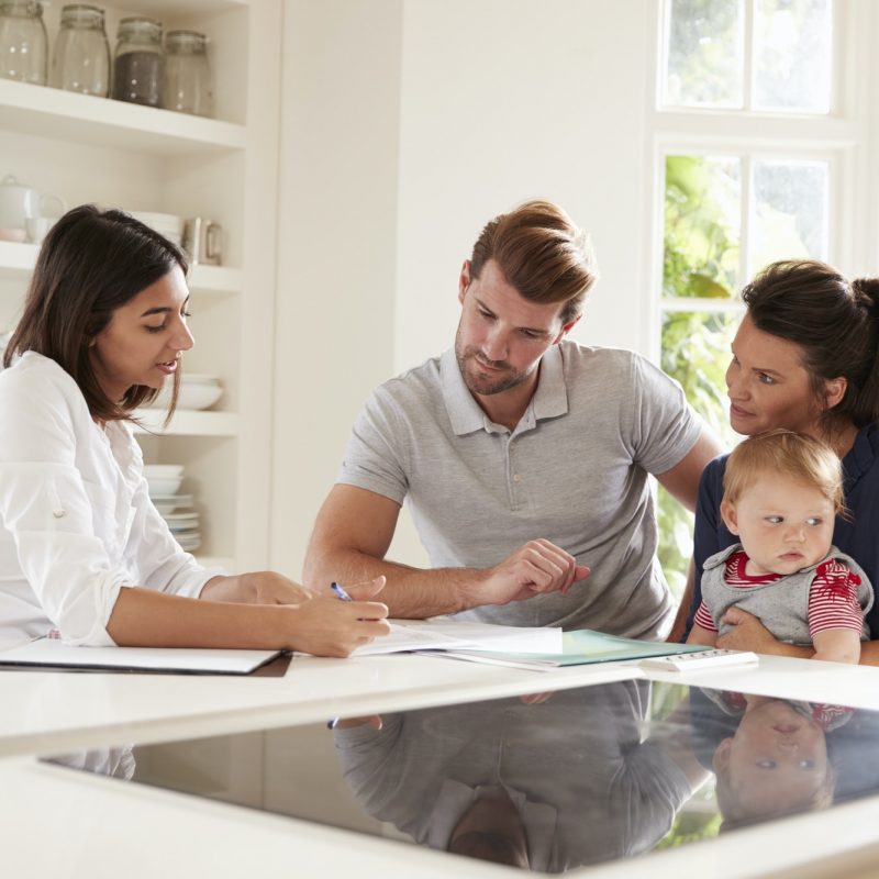 Family With Baby Meeting Financial Advisor At Home