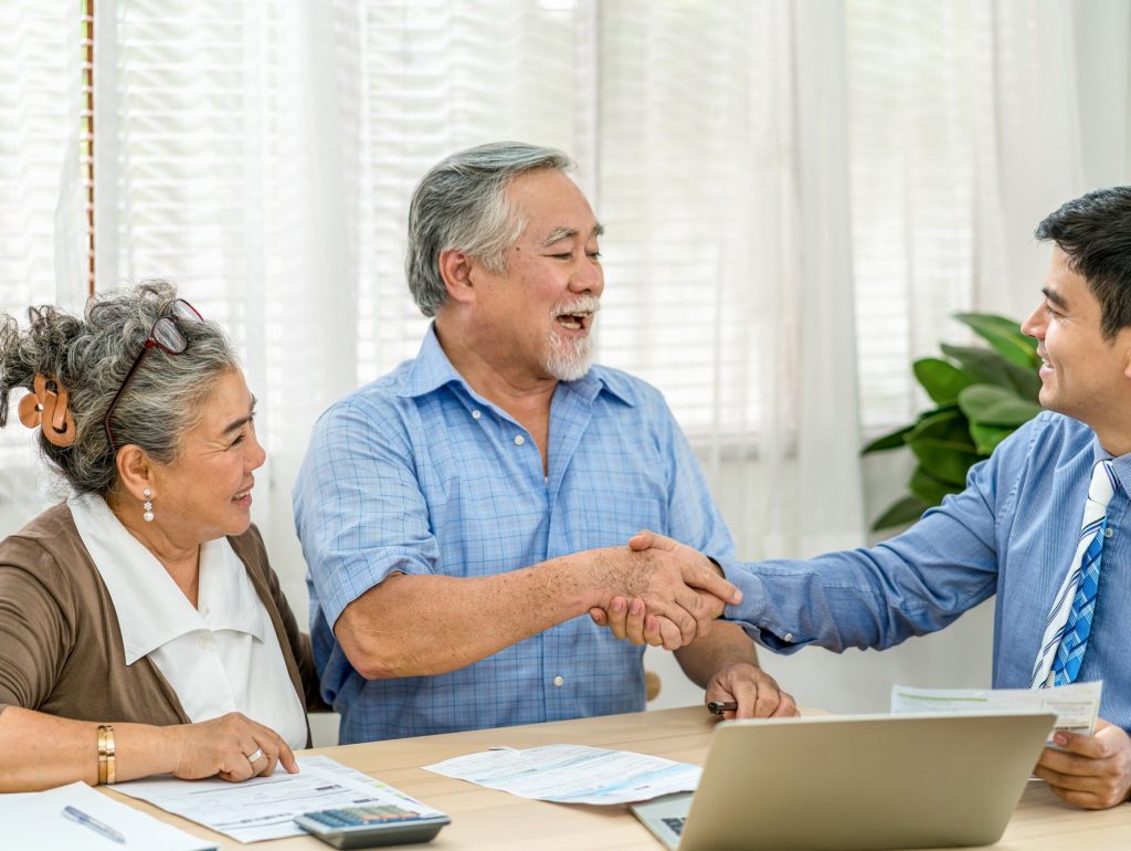 Insurance agency manager handshake with Asian couple grandparent in happy feeling after deal